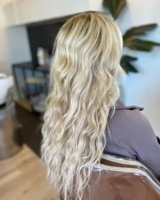 Full head of long blonde hair extensions blended seamlessly with natural hair
