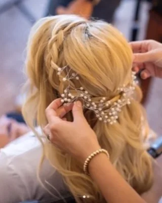 Stylist pinning a pearl hair vine into a blonde bridal updo at Salon Social