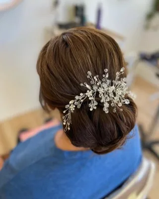 Romantic bridal updo finished with a crystal hair pin
