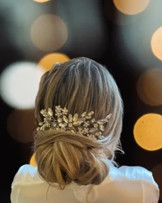 Elegant low bridal bun finished with a gold hair vine, styled at Salon Social