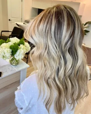 Bright dimensional blonde balayage with beachy waves, done at Salon Social