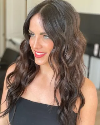 Client smiling after a full head of seamless brunette hair extensions at Salon Social