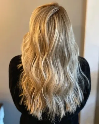 Dimensional golden blonde highlights styled in soft waves at Salon Social